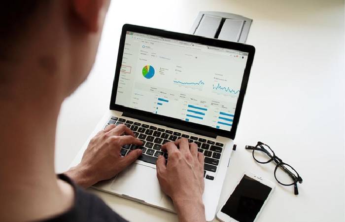 Employee analyzing data for a report on his laptop.